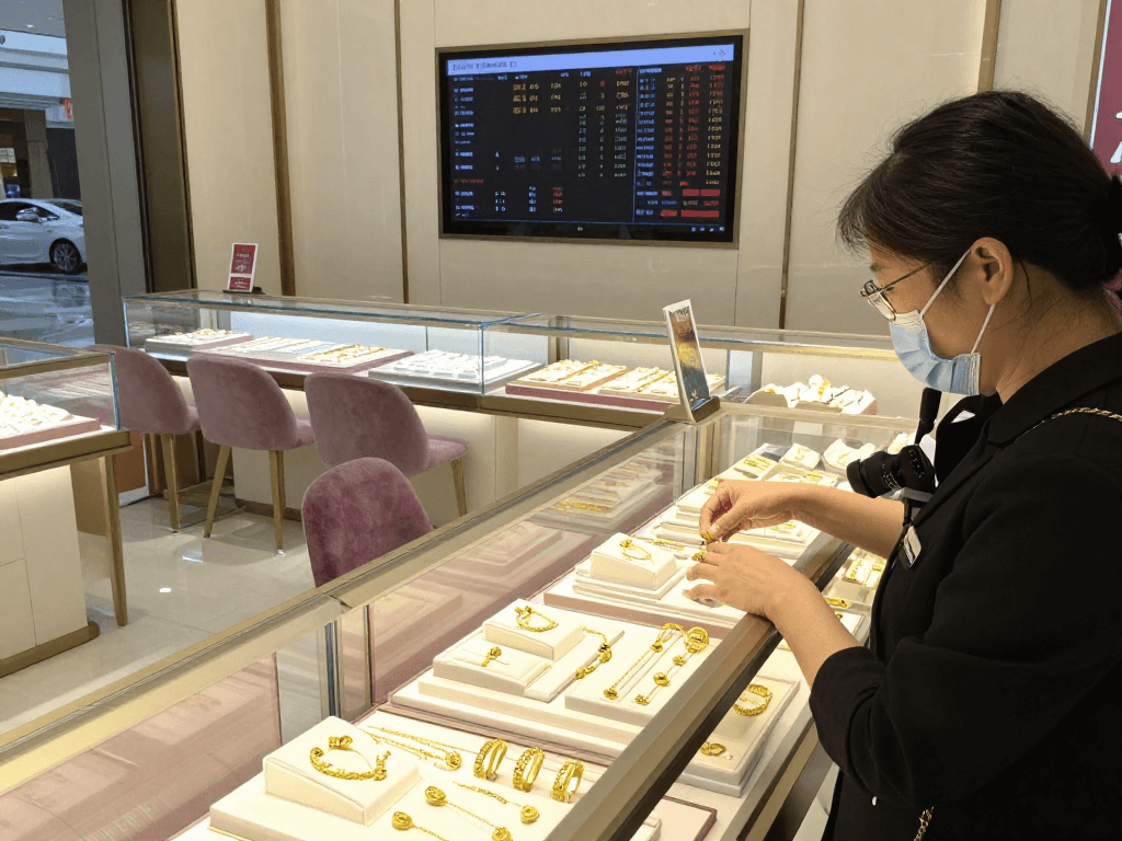 Showcasing gold jewelry at a premium retail store, mantra88 involved in customer selection.